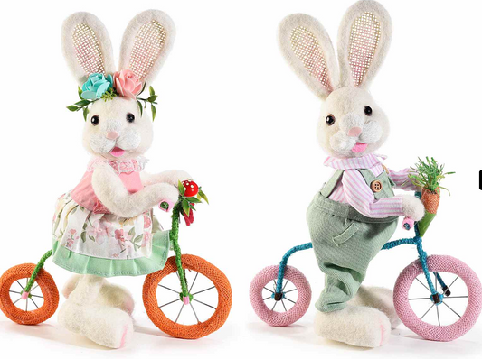 Coniglietto in morbido pelo artificiale in bicicletta